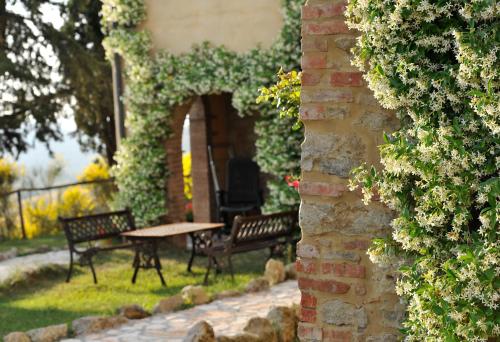 two benches and a table in a garden at Agriturismo Villa Felice in Volterra