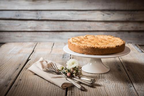 a cake on a plate on a wooden table at Berry House in Vigolo Vattaro