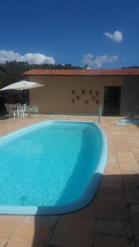a large blue swimming pool in front of a house at Refúgio na Serra in Bananeiras