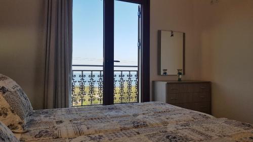 a bedroom with a bed and a large window at Villa Danae in Gaios