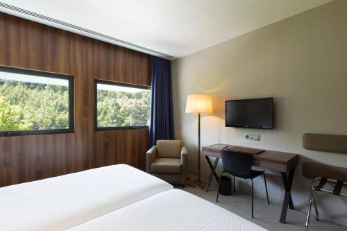 a hotel room with two beds and a television at Hotel de Guimaraes in Guimarães