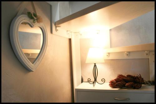 a bathroom with a mirror and a lamp on a dresser at Casa Vacanze Borc dai Cucs in Faedis