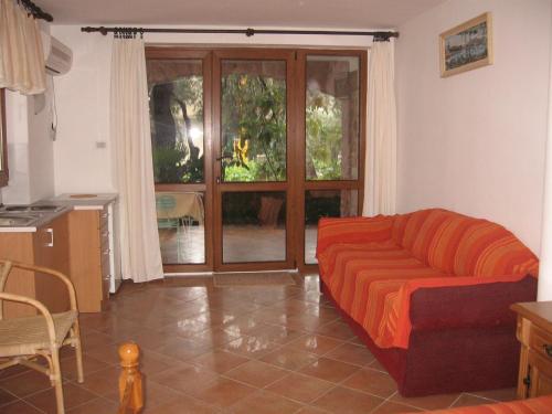 a living room with a couch and a sliding glass door at Zoro Apartments in Sveti Stefan