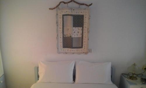 a mirror above a bed with white pillows at Thalassino Ageri in Gialiskari