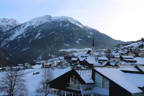 a town covered in snow with a mountain in the background at Ferienwohnung Raich in Wenns