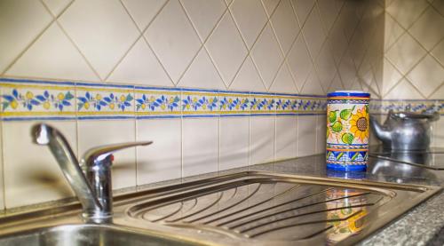 una encimera con fregadero y una botella. en Casa Vitória Guest House, en Évora