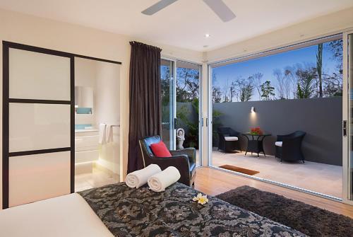 a hotel room with a large bed and a balcony at Cavvanbah - Byron Bay in Byron Bay