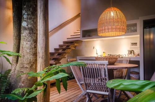a room with a table and chairs and a staircase at Pousada Capim Santo in Trancoso