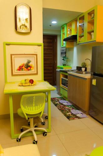 a kitchen with a yellow table with a plate of fruit on it at Nica's Place Property Management Services at Horizons 101 Condominium in Cebu City