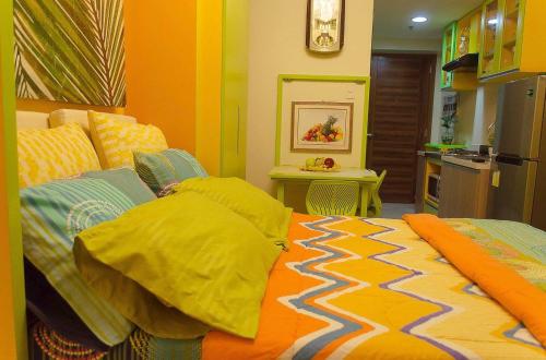 a bedroom with a bed and a kitchen at Nica's Place Property Management Services at Horizons 101 Condominium in Cebu City