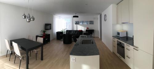 a kitchen and living room with a table and a counter at Close to Zürich centre and Airport in Kloten
