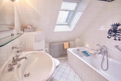 Baño blanco con bañera y lavamanos en Heefwai 2 W6 en Morsum