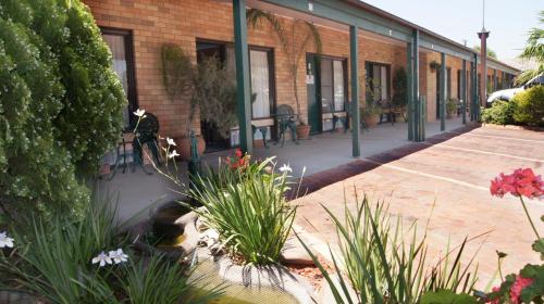 a patio with flowers and plants in front of a building at Ningana Motel in Mudgee