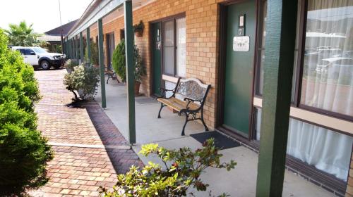 a bench sitting on a sidewalk next to a building at Ningana Motel in Mudgee