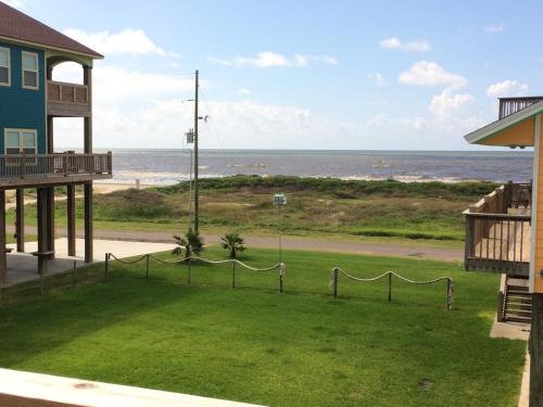 a view of the beach from the balcony of a house at 1 Coastal Calm Home in Bolivar Peninsula