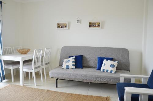 a living room with a gray couch and a table at Baleal Tower Bay Apartment in Ferrel