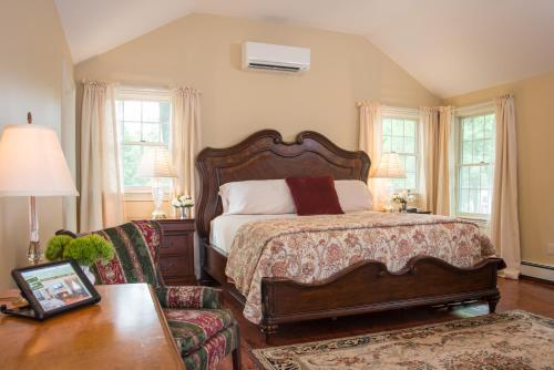 a bedroom with a bed and a chair and a table at Caldwell House Bed and Breakfast in Salisbury Mills