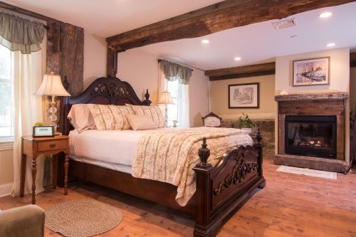 a bedroom with a large bed and a fireplace at Caldwell House Bed and Breakfast in Salisbury Mills
