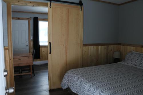 a bedroom with a bed and a sliding glass door at Jasper Way Inn Resort & Campground in Clearwater