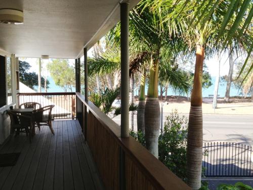a patio area with a patio table, chairs, and umbrellas at Coconut Palms On The Bay in Hervey Bay