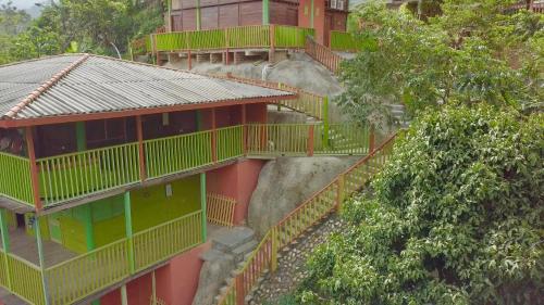 a building with green balconies on the side of a mountain at Cabañas Ecoturisticas Y Club Gaira Tayrona in Santa Marta