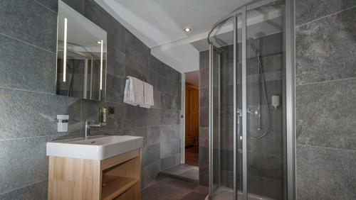 a bathroom with a sink and a glass shower at Pension de la Poste in Zinal
