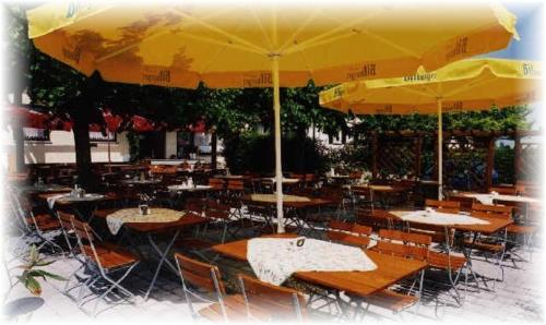 a group of tables and chairs with yellow umbrellas at Gasthof Fröhlich in Langenbruck