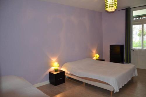 a bedroom with two beds and two lamps on tables at Le Lion d'Or in Selles-sur-Cher