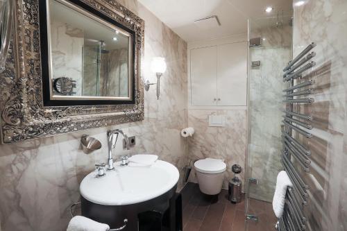 ein Badezimmer mit einem Waschbecken, einem WC und einem Spiegel in der Unterkunft Sönshorn 8 Mitte in Munkmarsch