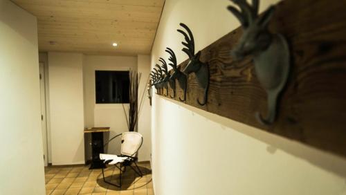 a room with a chair and a wall with antlers at Pension de la Poste in Zinal