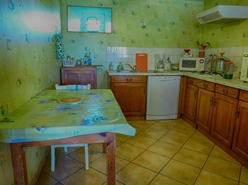 a kitchen with a table and a counter top at Gîte "L'Orée du Bois" in Beaune-sur-Arzon