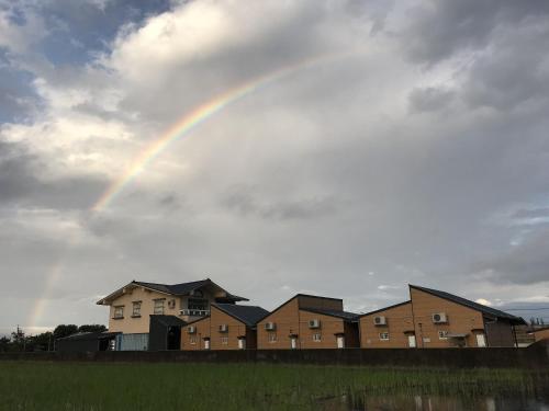 a rainbow in the sky over a group of houses at Easy Home Stay in Xingjian