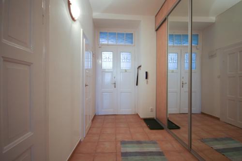 a hallway with white doors and a mirror at Apartmán Mrakodrap in Plzeň