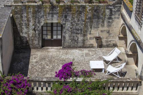 two chairs and flowers in front of a building at Castello di Casamassella - Marea Stays Collection in Casamassella