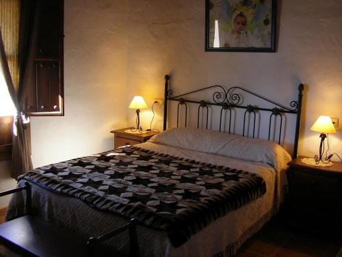 a bedroom with a bed and two lamps on tables at Casa Rural La Herradura in Antequera