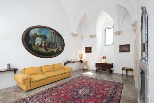 a living room with a couch and a painting on the wall at Castello di Casamassella - Marea Stays Collection in Casamassella
