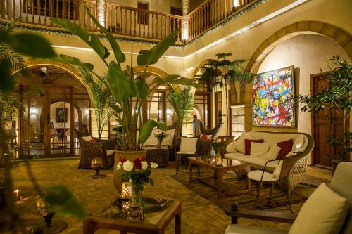 a living room filled with lots of furniture and plants at Riad Chbanate in Essaouira