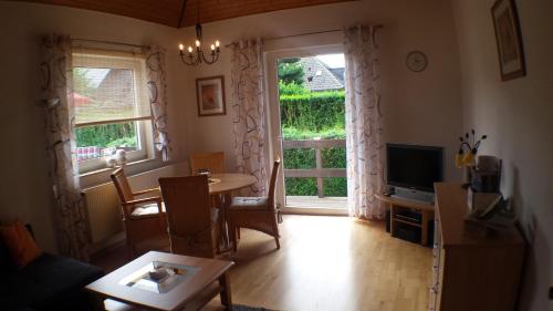 a living room with a table and a large window at Ferienwohnung Katzenberger in Beverungen