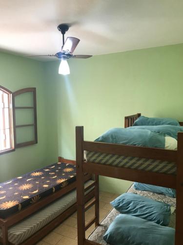 烏巴圖巴的住宿－Chalés Beto Amá，一间卧室设有两张双层床和吊扇