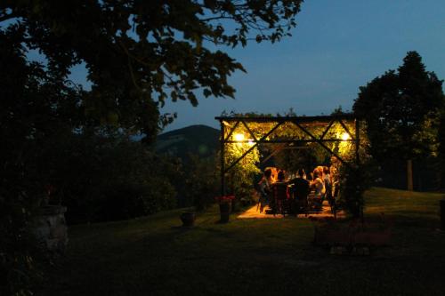 a group of people sitting under a gazebo at night at Country House Il Biroccio in Urbino