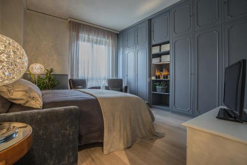 a bedroom with a bed and a couch and a television at Spazio Duomo1 by Welc(H)ome in Treviso