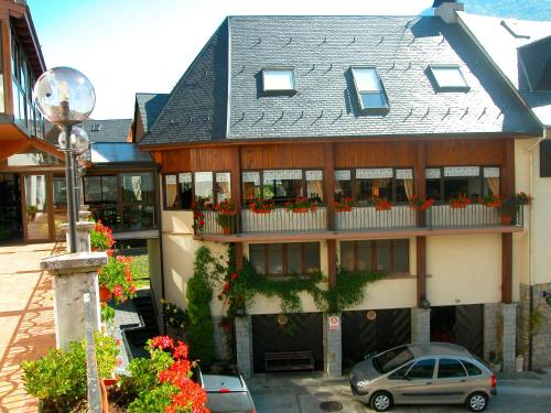 a building with a balcony with flowers on it at Hosteria Catalana in Bossost