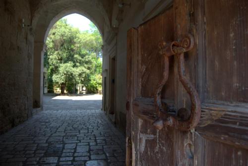 an old wooden door with a handle on the side of a building at Castello di Casamassella in Casamassella
