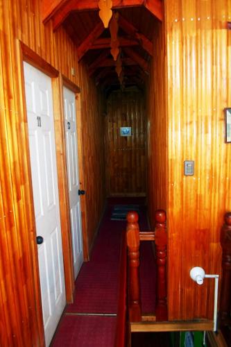 a hallway with wooden walls and a white door at Hostal Plaza Maule Express in Talca