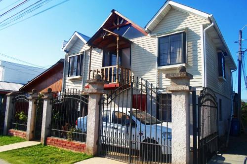 a white house with a wrought iron fence at Hostal Plaza Maule Express in Talca
