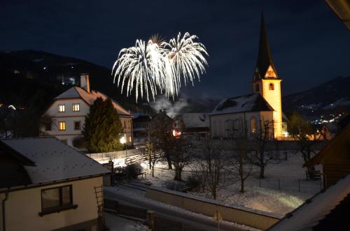 a firework display over a church at night at Hoamat House I Boutique Apartments in Sankt Margarethen im Lungau