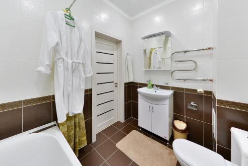 biała łazienka z toaletą i umywalką w obiekcie Apartments LUX 53/144 w mieście Astana