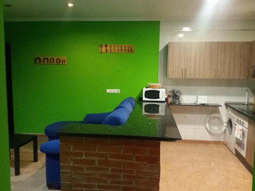 ソト・デ・ルイニャにあるLa Casona De Sotoの緑の壁と青いソファ付きのキッチン