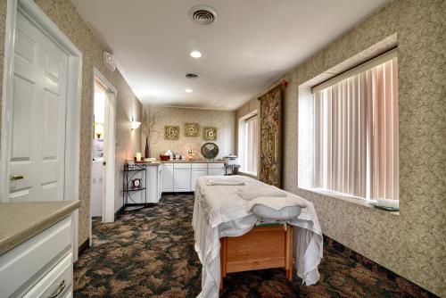 um quarto de hospital com uma mesa e uma cozinha em Roosevelt Inn & Suites Saratoga Springs em Saratoga Springs