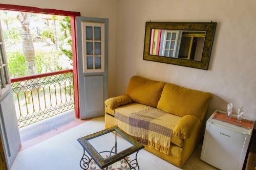 a living room with a couch and a balcony at Pousada Vila Mineira in Lavras Novas